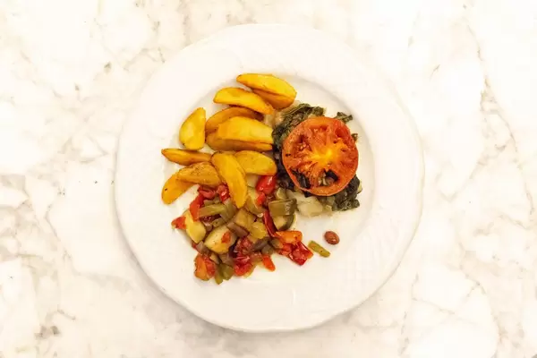 Aufsicht - gegrillter Schwertfisch mit Wedges Kartoffeln und Gemüse auf einem Teller