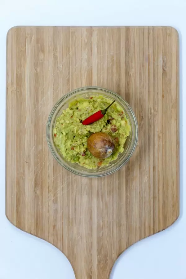 Aufsicht - Guacamole Avocado Dip - Brotaufstrich in Schälchen mit roter Chili und Aocadokern