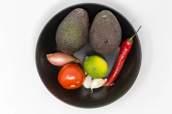 Aufsicht - Guacamole Mix Zutaten - Avocado, Tomate, Zwiebel, Knoblauch, Limette und Chilischote