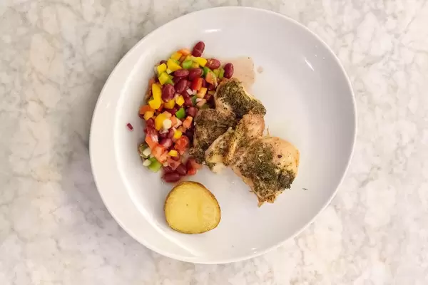 Aufsicht - Hähnchen in Kräutersauce mit Backkartoffel und gemischtem Salat mit Bohnen