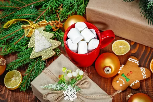 Aufsicht - Weihnachtsgeschenk, Tasse mit Marschmallows, Lebkuchenmann und Tannenzweigen