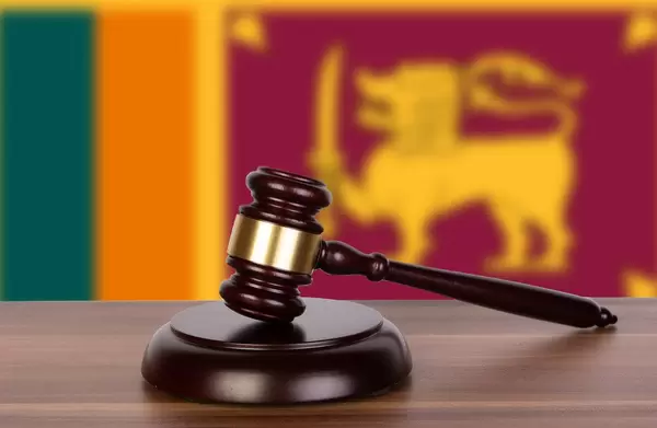 Auktionshammer / Richterhammer auf einem Holzuntergrund, vor der Flagge von Sri Lanka