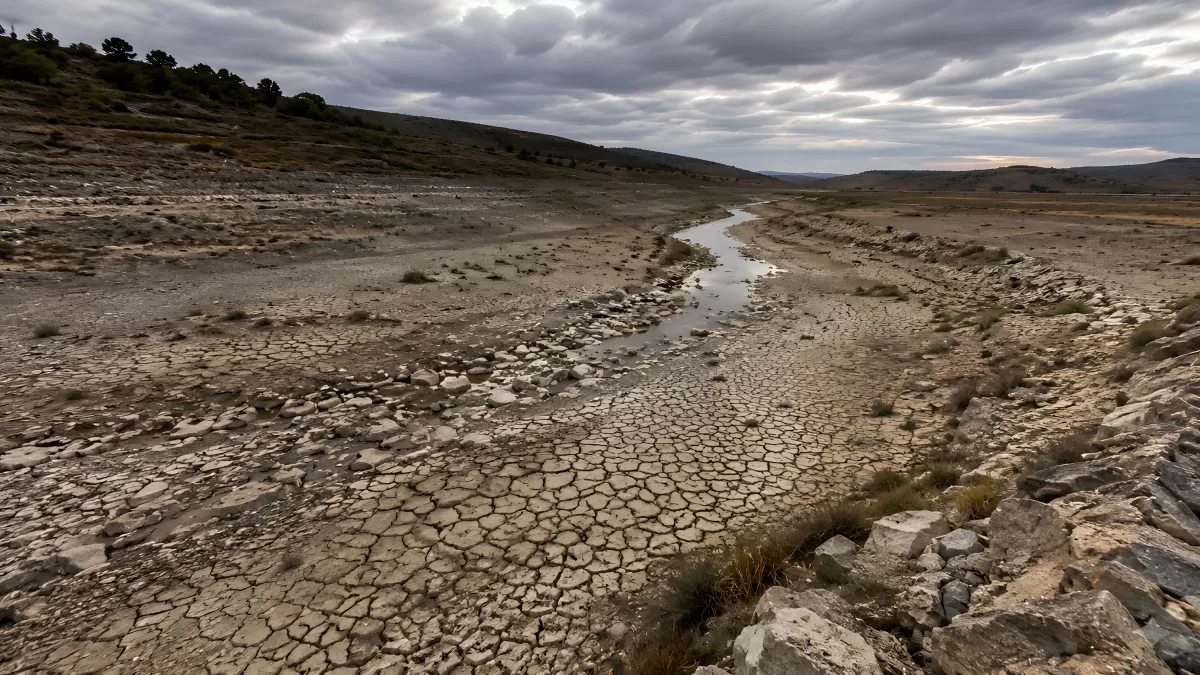 Ausgetrocknetes Flussbett mit Rissen in karger Landschaft