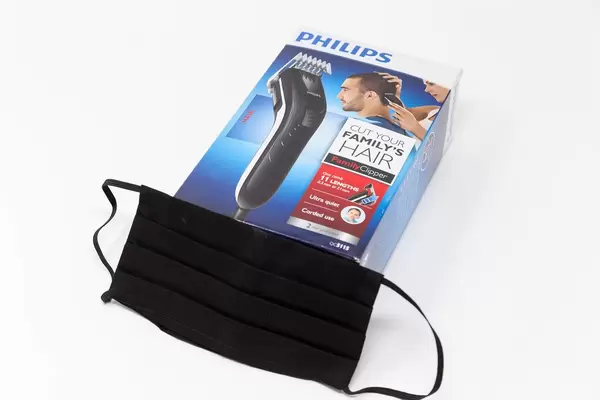 Ausrüstung für Corona-Zeiten: schwarzer Mundschutz und Haarschneider Philips QC5115/15 von Philips