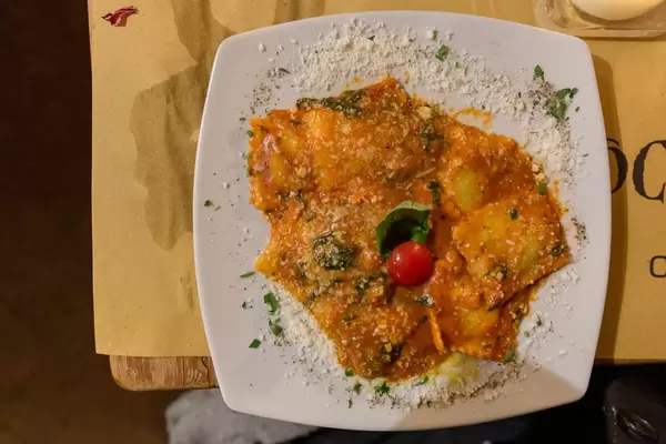 Authentic italian ravioli with tomato sauce and basil at mimi e cocos wine bar in Rome