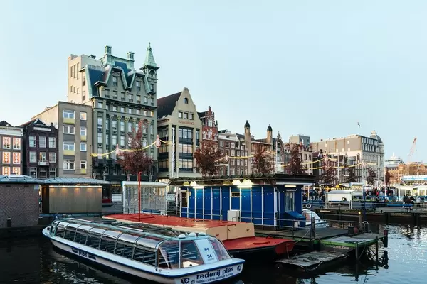 Authentic old buildings in downtown Amsterdam with pier and boats in the foreground