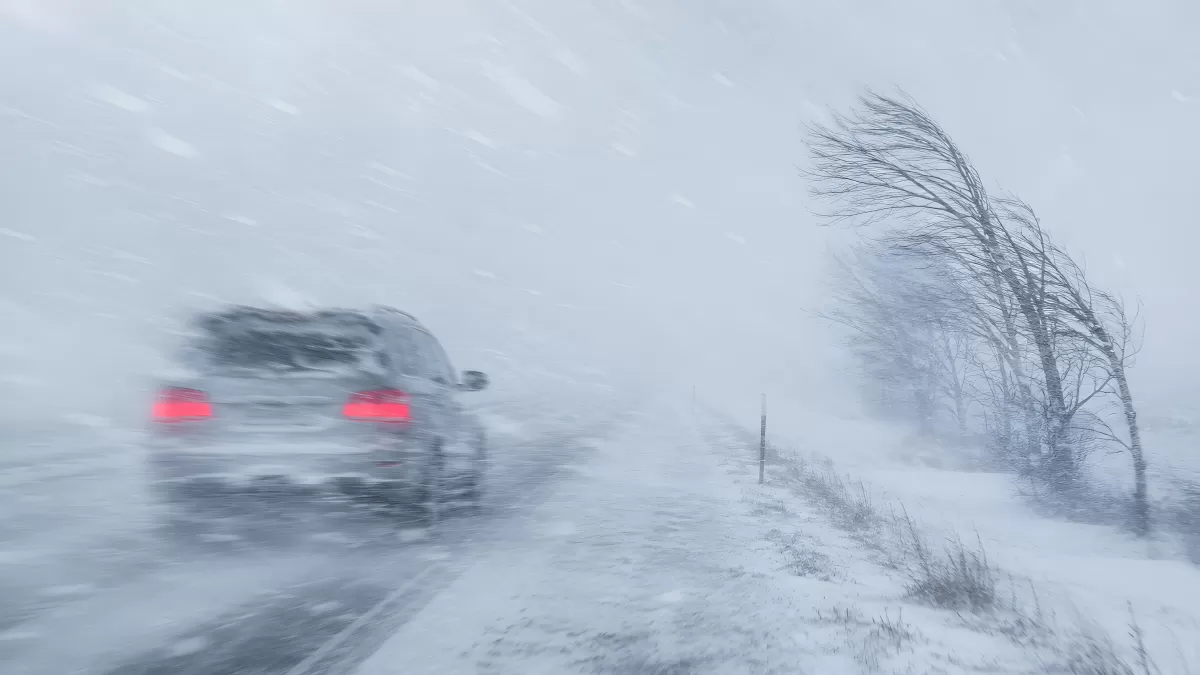Auto fährt durch heftigen Schneesturm auf Landstraße