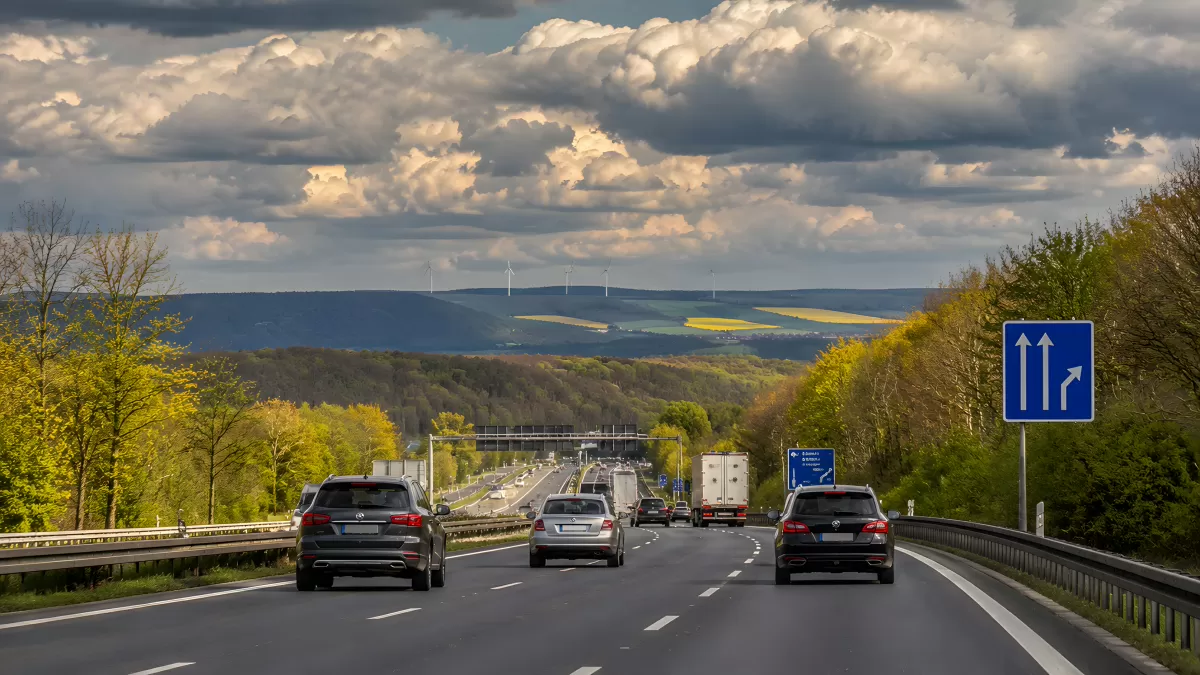Autobahn durch grüne Landschaft mit Windrädern