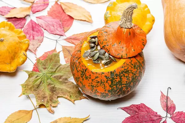 Autumn background with colorful dry leaves and pumpkins on a white wooden background (Flip 2019)