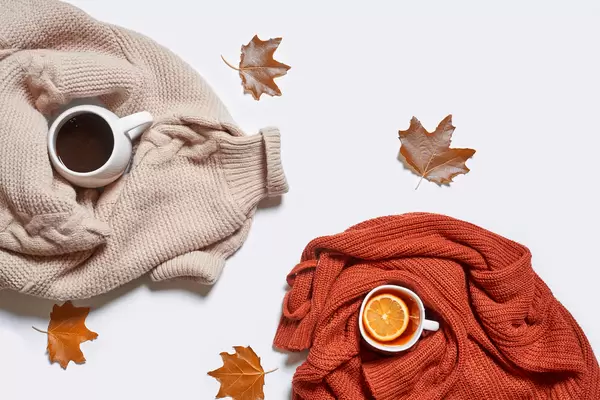 Autumn background with fall leaves, cup of tea and coffee on white table