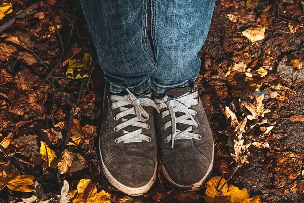 Autumn concept with women's feet in shoes on yellow dry leaves (Flip 2019)