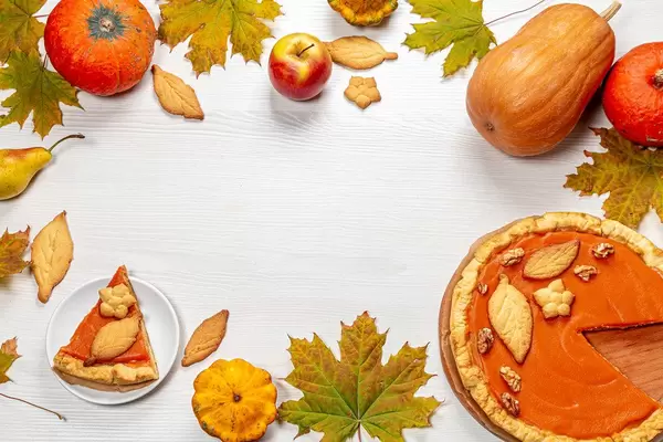 Autumn frame with leaves, pumpkin pie, pumpkins, apples and homemade cookies on white wooden background (Flip 2019)