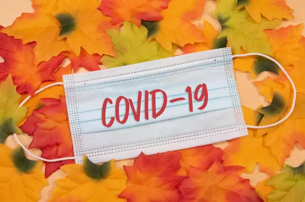 Autumn leaves with medical face mask and Covid-19 text