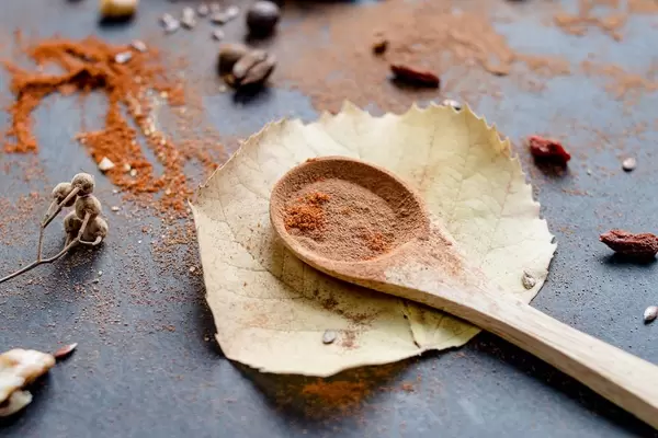 Autumn mood with autumn leaves, wooden spoon with cinnamon