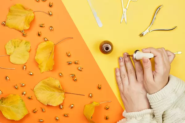 Autumnal manicure. Woman hands making nails painted with gentle nail polish