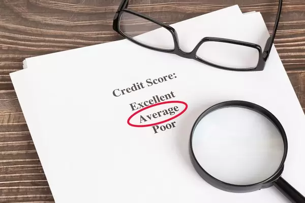 Average Credit Score result with glasses on wooden table