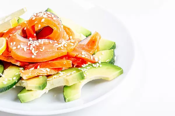 Avocado and smoked red fish salad on a white plate