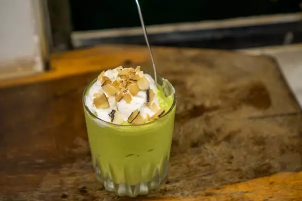 Avocado Coconut Ice Cream with Almond Flakes in a Glass with Spoon