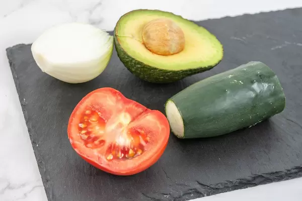Avocado Tomato Onion and Cucumber on the black tray