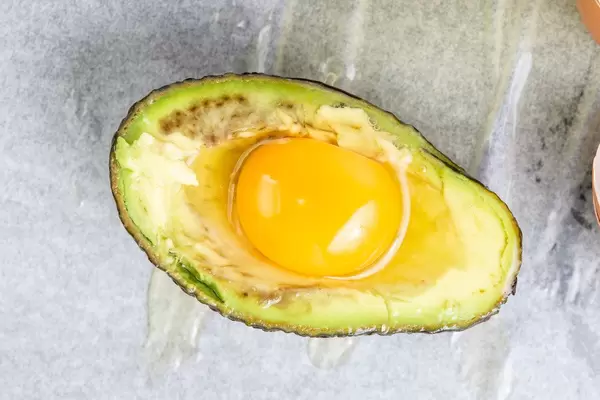 Avocado with raw Eggs ready for baking