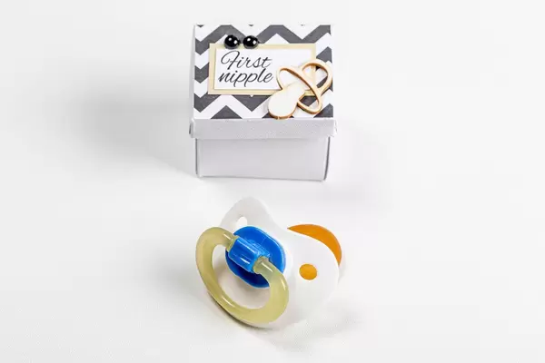 Baby pacifier and box on a white background