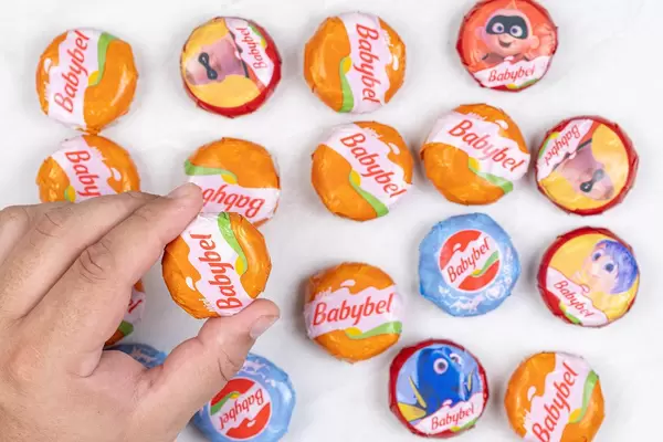 Babybel small cheese packed in small packages in the hand