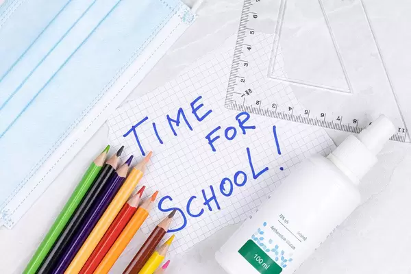 Back to School concept with virus protective masks and alcohol