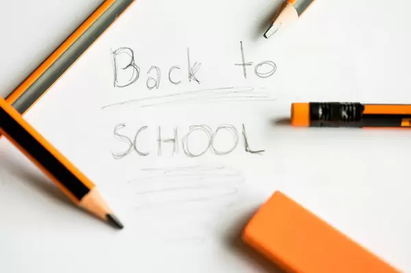 Back to School geschrieben auf Papier zwischen mehreren Bleistiften