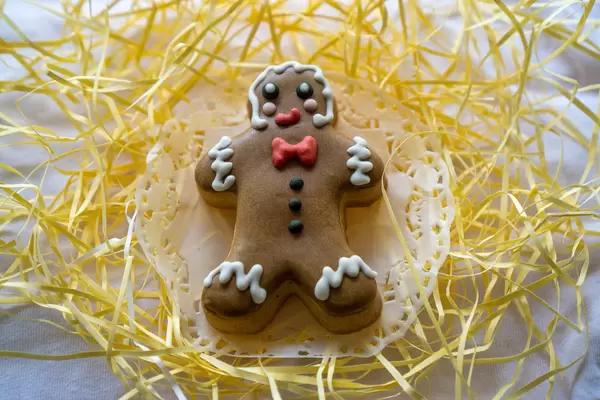 Backen zu Weihnachten Lebkuchenmann mit Zuckerglasur dekoriert auf weißem Papier