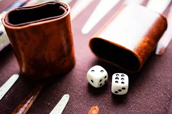 Backgammon Würfelbecher mit Würfeln auf einem Backgammonbrett
