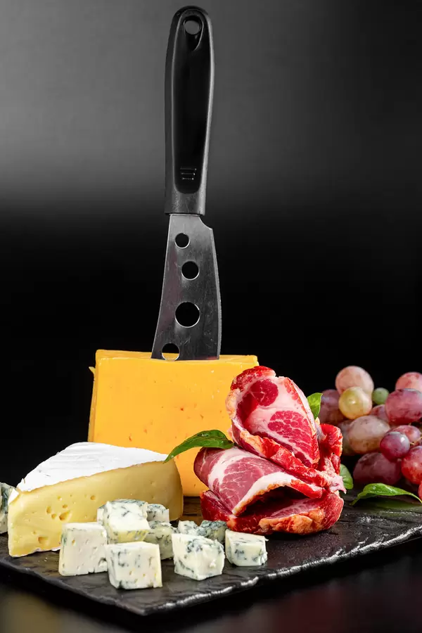 Background of delicious types of cheese and smoked ham with fresh grapes