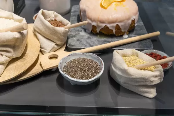 Backzutaten in Leinensäcken und Keramiktöpfen, für einen glutunfreien Orangenkuchen mit Zuckerguss