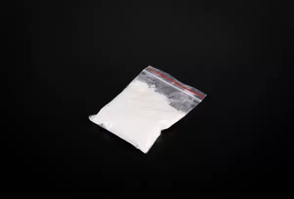 Bag with cocaine on dark background