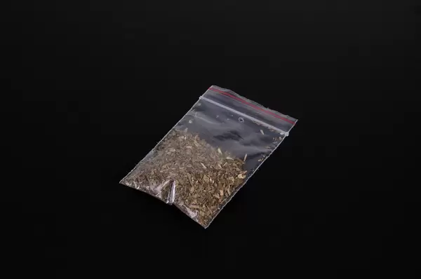 Bag with marijuana on black background