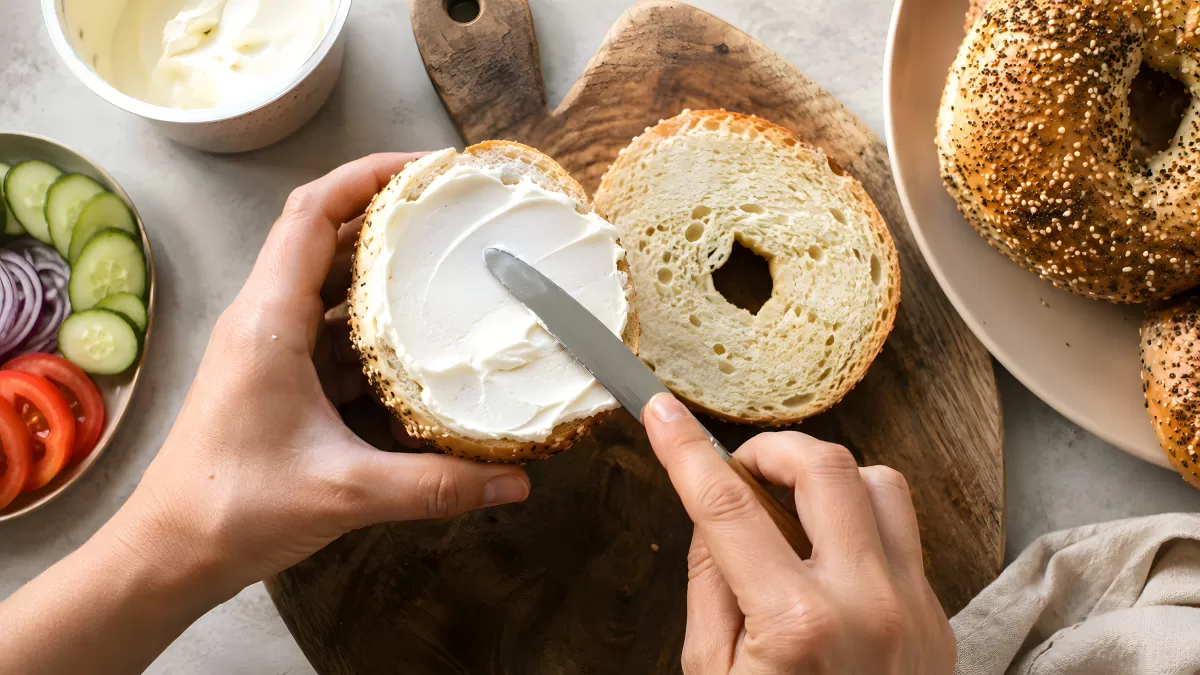 Bagel mit Frischkäse bestreichen – Draufsicht
