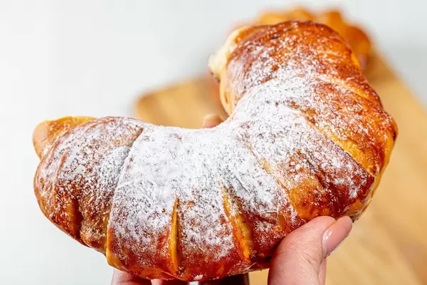 Bagel with powdered sugar in a woman's hand (Flip 2019)