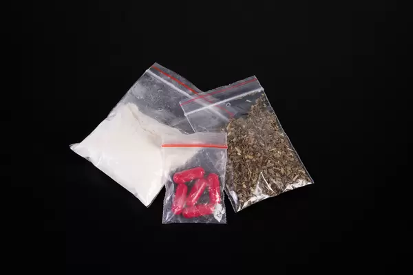 Bags with drugs on black background
