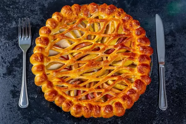 Baked Apple pie with knife and fork. Top view