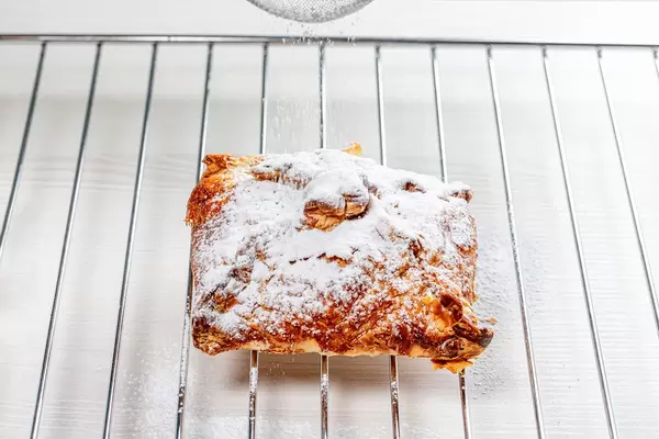 Baked apple strudel sprinkled with powdered sugar (Flip 2019)