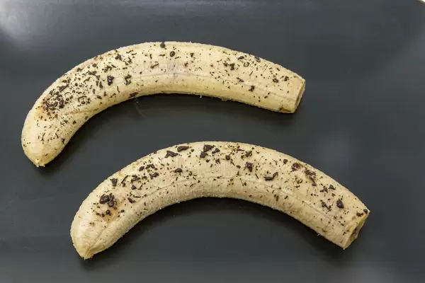 Baked Bananas with melted chocolate on black plate
