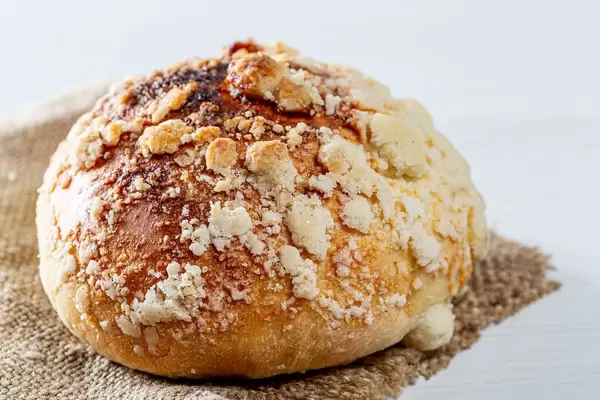 Baked bun with sugar crumbs on burlap