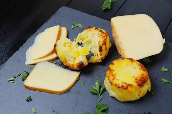 Baked cheesy bites on black background