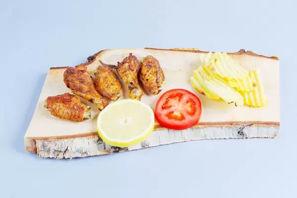 Baked chicken wings on a wooden chopper