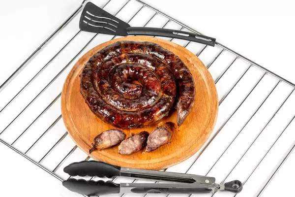 Baked homemade sausage on kitchen board with slices