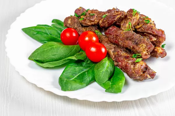 Baked lamb with spinach and cherry tomatoes