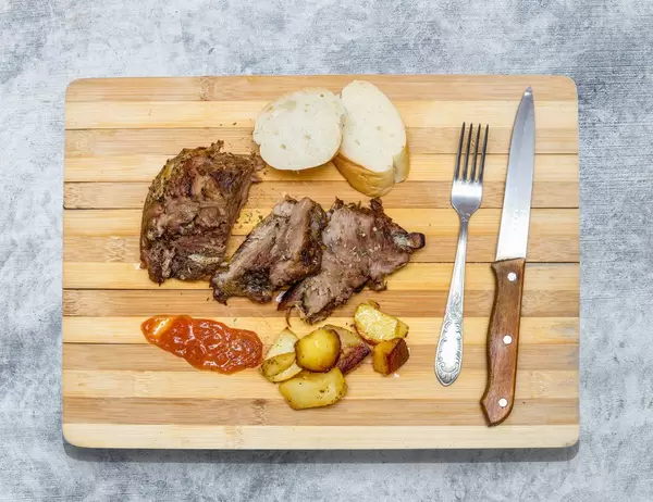 Baked meat on wooden board