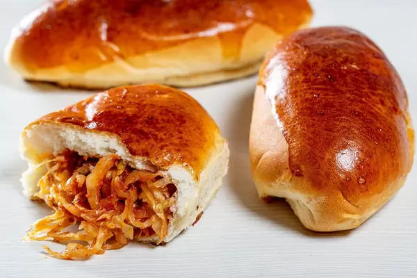 Baked pies with cabbage on a light background