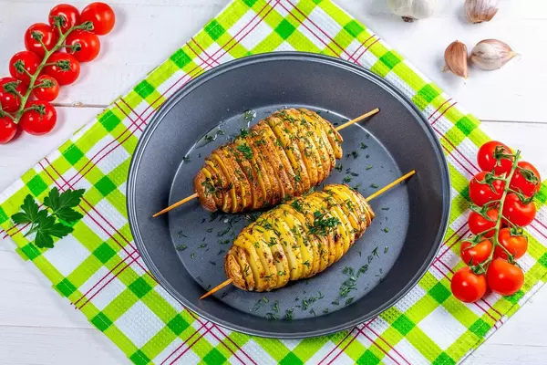 Baked potatoes on skewers with herbs and cherry tomatoes. Top view (Flip 2019)
