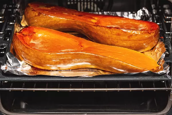 Baked pumpkin halves on a baking sheet in the oven