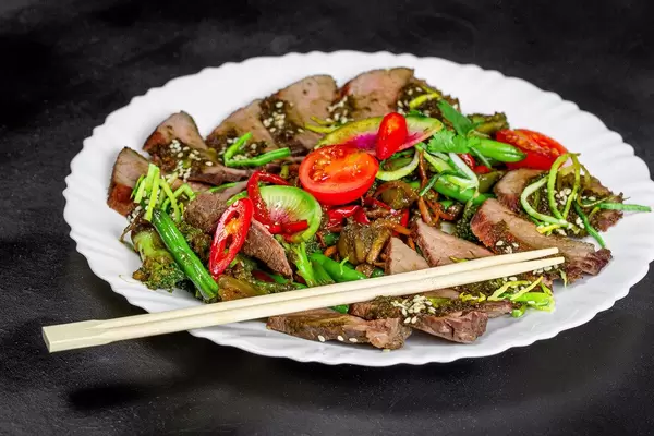 Baked vegetables and beef with chopsticks